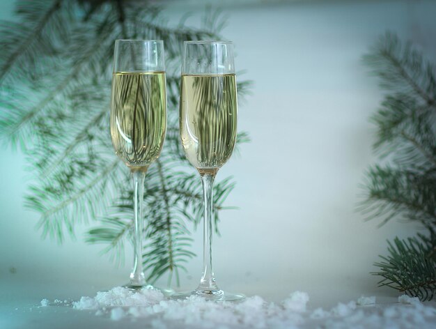 Two glasses with champagne and boxes with gifts on christmas b