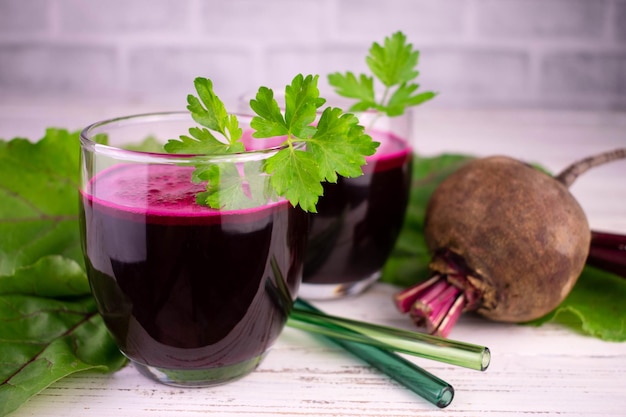 Two glasses with healthy beetroot juice on a white wooden background.Close-up.