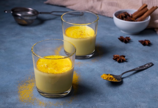 인도 아유르베다 선택적 초점에서 심황 분말 치유 음료에서 건강하고 맛있는 황금 우유 두 잔