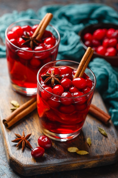 Two glasses with a hot drink of cranberries and apples with spices, mulled wine, punch or grog.