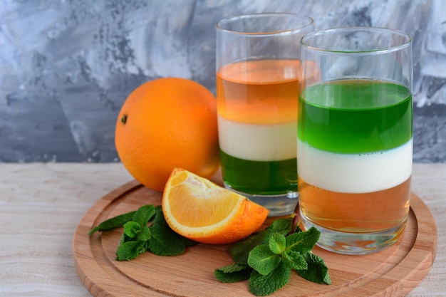 two glasses with kiwi milk and orange jelly
