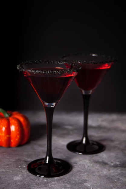 Фото Два бокала с красным коктейлем для хэллоуина на темноте