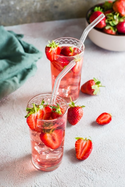 Два стакана с клубничным коктейлем и миска ягод на столе домашние напитки