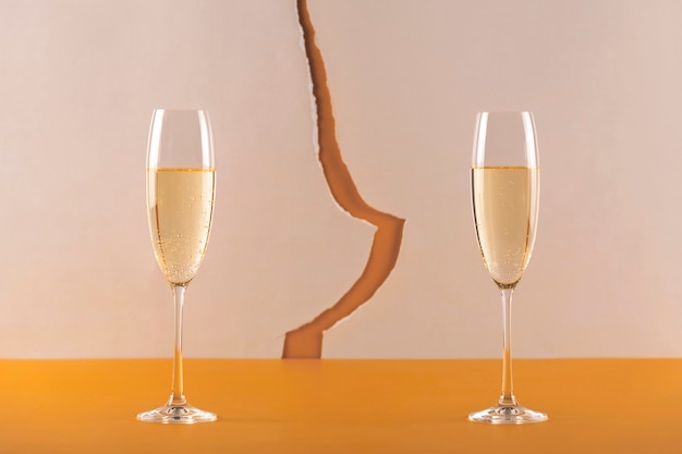 Foto due glassess di champagne su uno sfondo con una crepa. concetto di natale diviso durante una pandemia