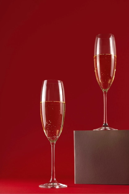 Two glassess of champagne on a stand on a red