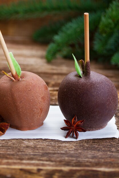 Two glazed in chocolate apples for christmas on table close up