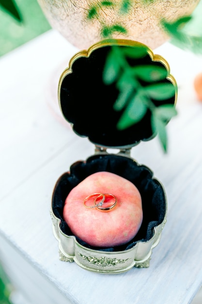 Two gold wedding rings in an elegant glass box