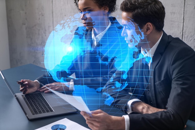 Два симпатичных бизнесмена работают над международным проектом Multiexposure World map Hologram