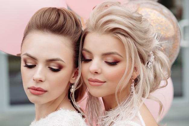 Two gorgeous models with make up and hairdo in white.