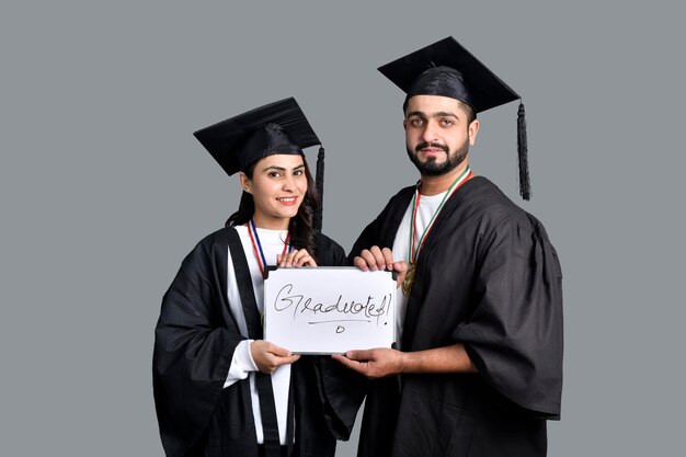 Due studenti laureati isolati su sfondo grigio modello pakistano indiano