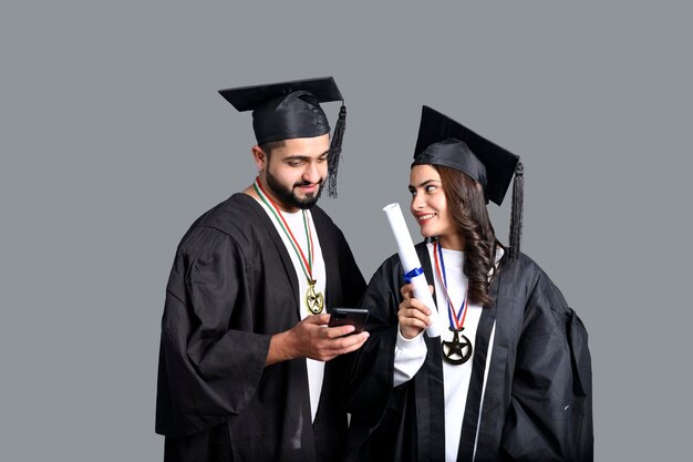 Due studenti laureati che utilizzano il modello pakistano indiano del telefono cellulare
