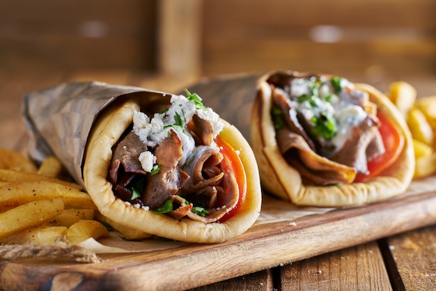 Two greek gyros with shaved lamb and french fries