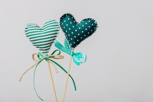 Two green hearts on wooden sticks.