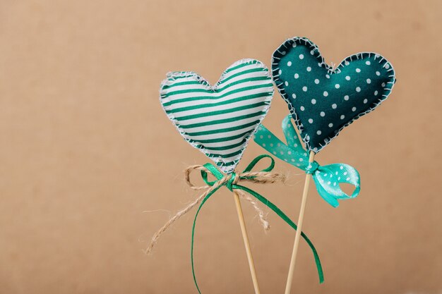 Two green hearts on wooden sticks.