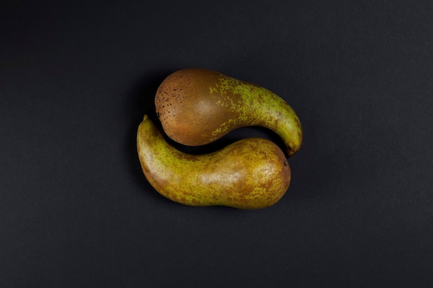 Two green pears lie in the form of a yin-yang symbol.