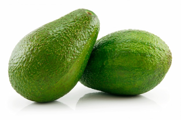 Фото Два зеленых спелых авокадо, изолированные на белом