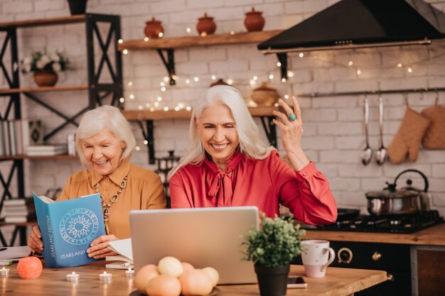 Two grey-haired pleasant ladies feeling good together