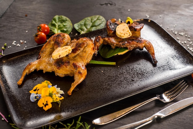 Two grilled quails on the wooden background