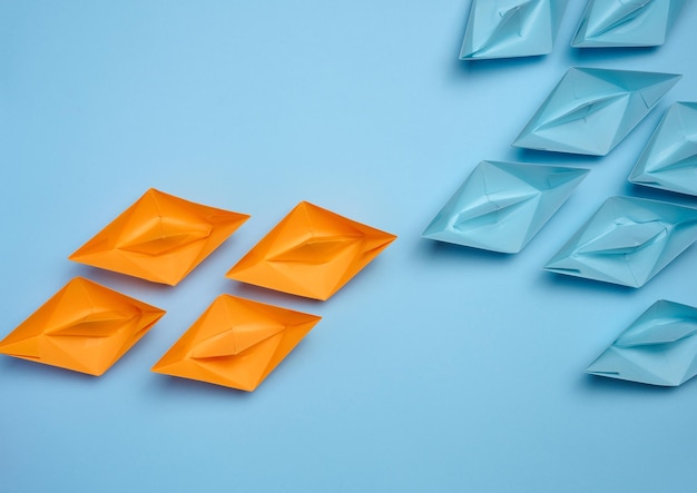 Two groups of paper boats facing each other a concept of confrontation