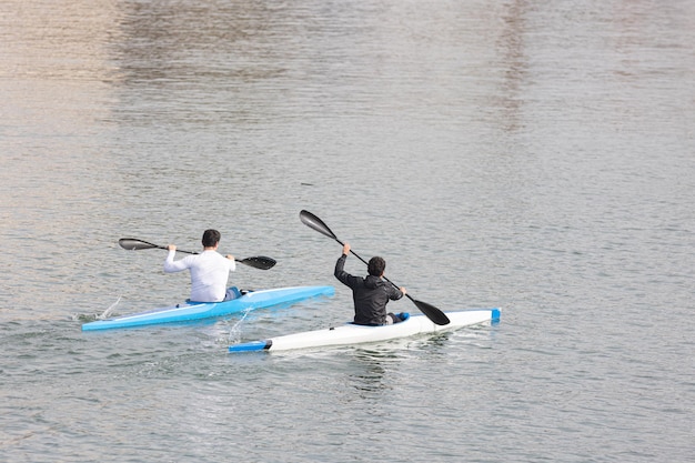 Two guys rowing in a canoe at marina