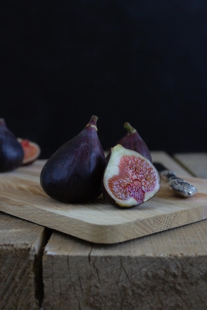 Photo two and a half fresh figs on the rustic style wooden table