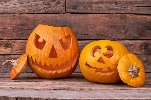 Two Halloween pumpkins on wooden background.