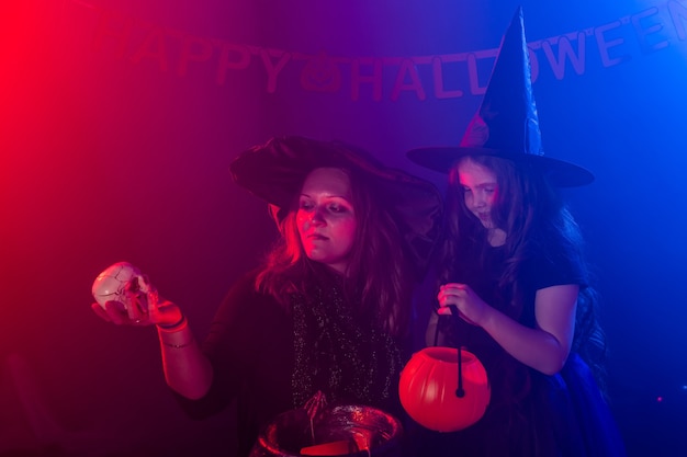 Two halloween witches making a potion and conjure in halloween night magic holidays and mystic