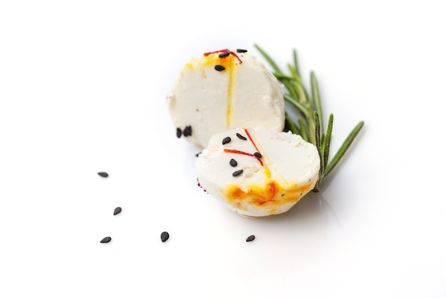 Two halves of cheese ball with sprig of thyme and sesame on white background