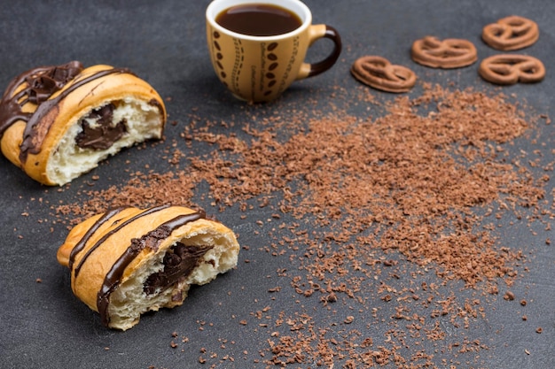 Foto due metà di croissant con una tazza di caffè al cioccolato spruzzato