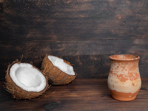 Two halves of fresh coconut and a vase