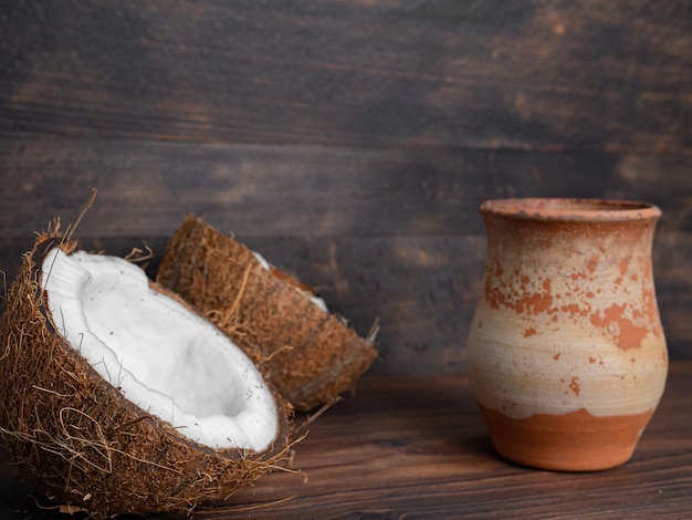 Two halves of fresh coconut and a vase