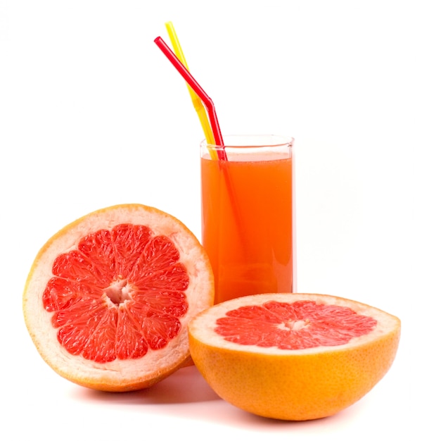 Two halves of grapefruit and juice in glass on white