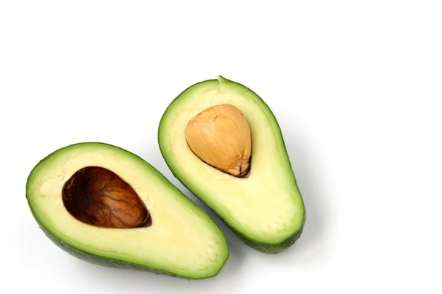 Two halves of ripe avocado lokaled on a white surface, copy space