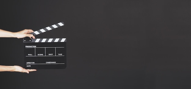 Two Hand's holding Clapperboard or movie slate use in video production ,film, cinema industry on black background.