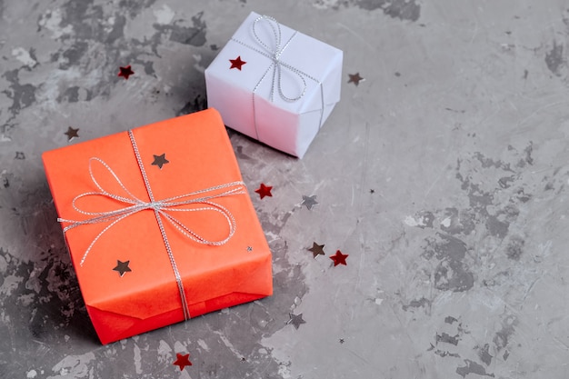 Two handcrafted festive presents wrapped in red and lilac paper 