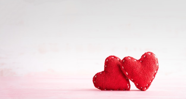 Two handmade red heart on bright wooden background. Valentine's day concept