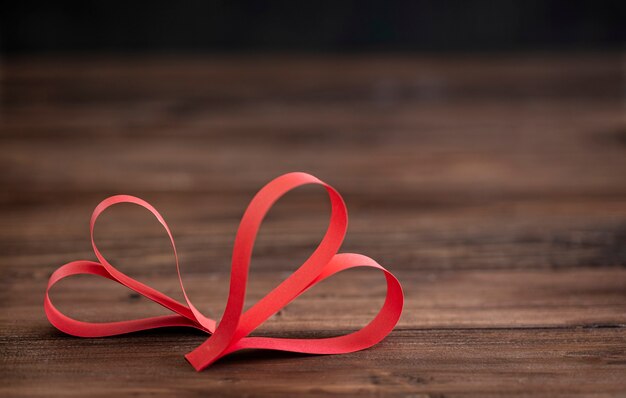 Two handmade red heart on brown wooden  background