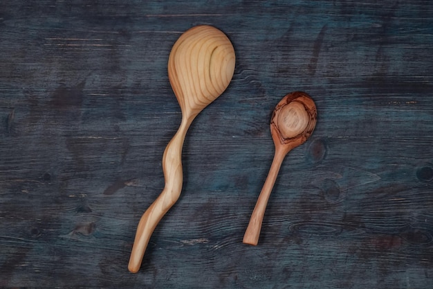 Foto due cucchiai di legno fatti a mano su fondo di legno