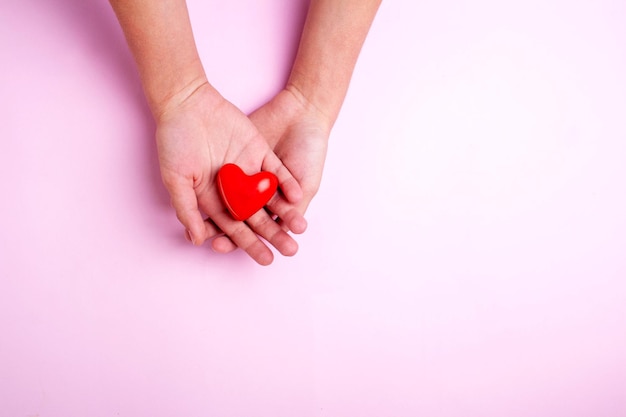 Two hands are holding a heart on a pink background Flatley style