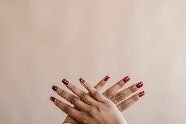 Two hands crossing on a beige background