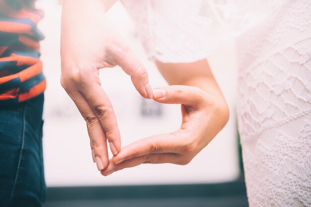 Two hands form a heart shape with their fingers