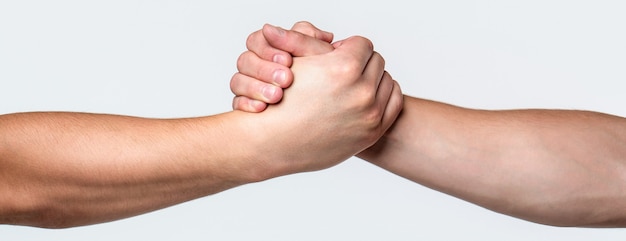 Two hands, helping arm of a friend, teamwork. Helping hand outstretched, isolated arm, salvation. Friendly handshake, friends greeting, teamwork, friendship. Rescue, helping gesture or hands