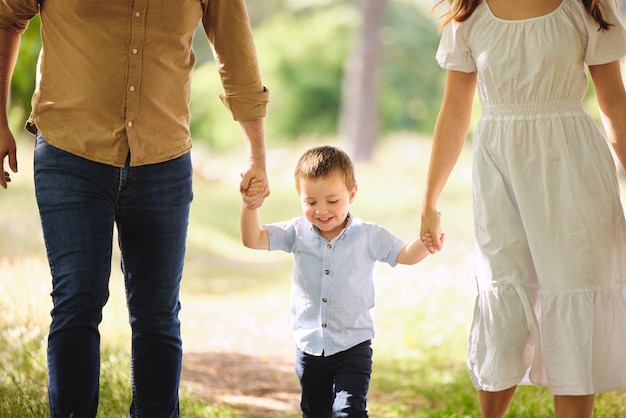 Foto due mani da tenere per tutta la vita. inquadratura di una famiglia che fa una passeggiata nel parco.