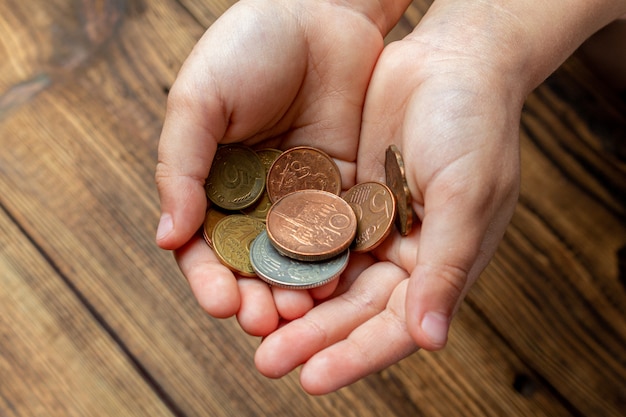 Photo two hands holding coins in the palms.