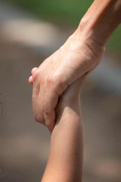 two hands holding each other with one being held up by another