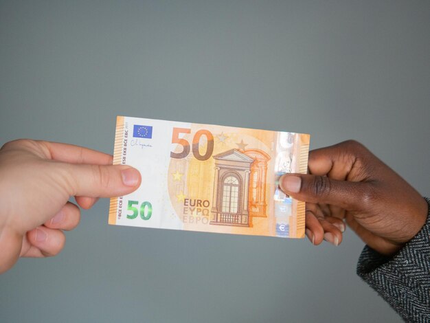 Photo two hands holding a fifty euro note