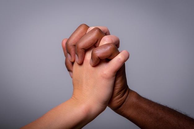 Two hands one white and one black shake Concept of multiethnicity and racism