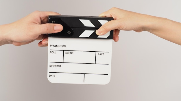 Two hands send and hold white small clapper board or movie slate on white background