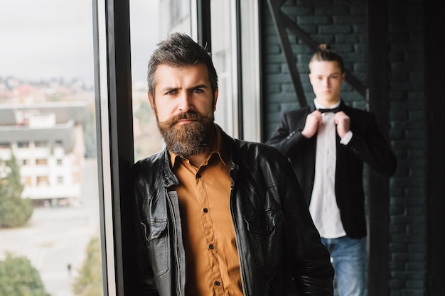 Two handsome guys model appearance on the terrace one on the\
background of the other