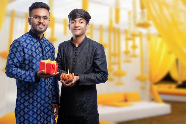 Two handsome men wearing traditional outfit Kurta and holding gift boxes and posing different poses